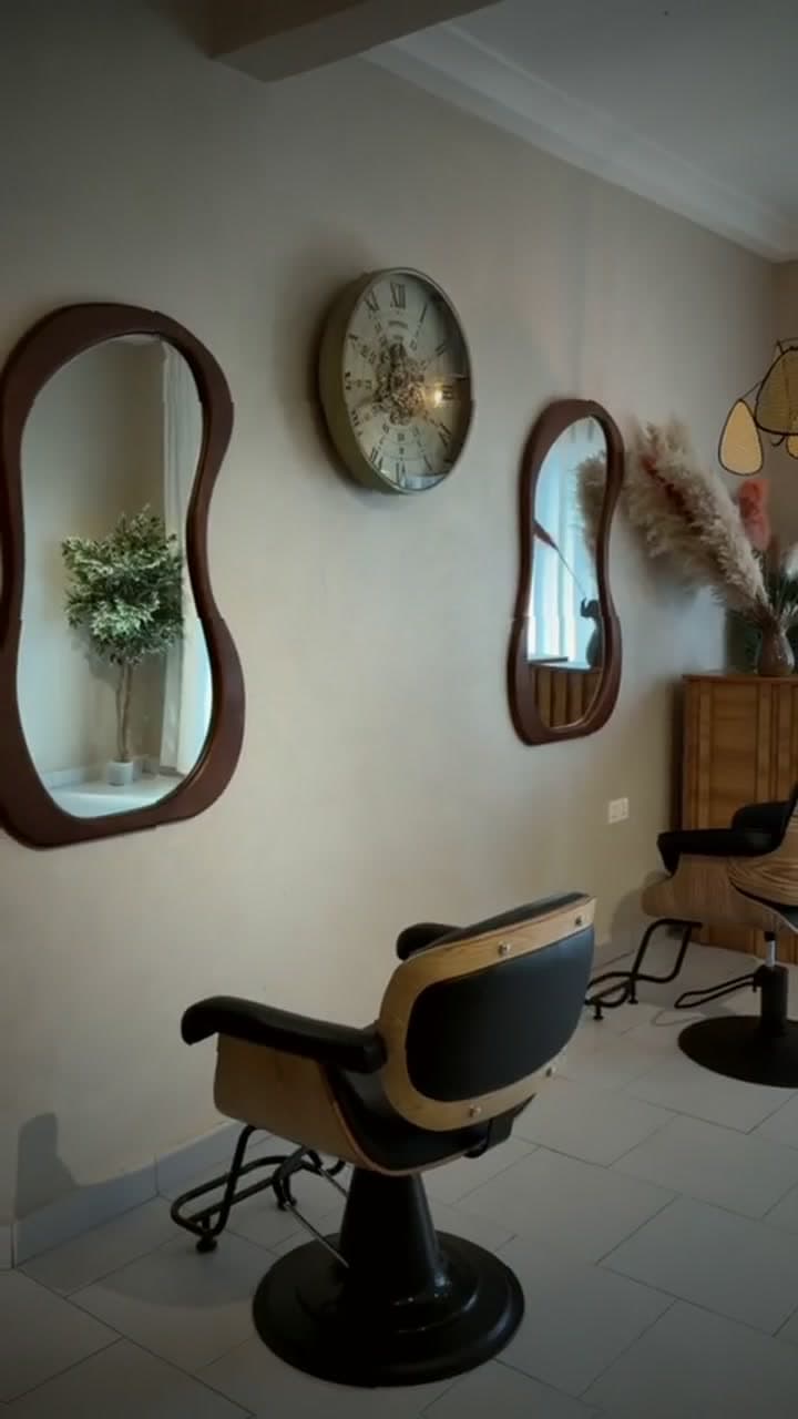 A styling chair set beneath curved mirrors in warm light
